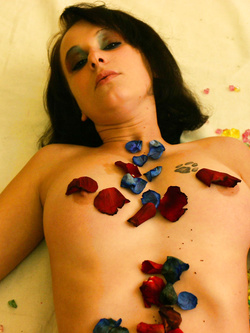 Natacha, posa in nudo sexi coprendosi le parti intime con fiori contornata da pietre colorate