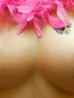 Natacha, posa in nudo sexi ed erotico contornata da piume colorate.