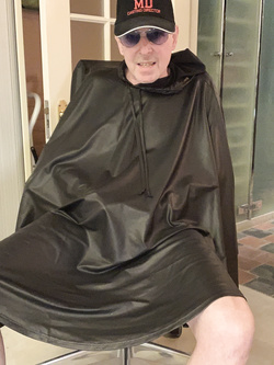 Lenny52, seduto nudo sulla poltrona di pelle nera della sua scrivania, ha indossato l'abito sintetico del parrucchiere.