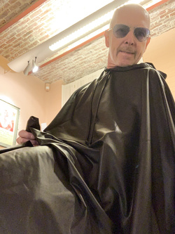 Lenny52, seduto nudo sulla poltrona di pelle nera della sua scrivania, ha indossato l'abito sintetico del parrucchiere.